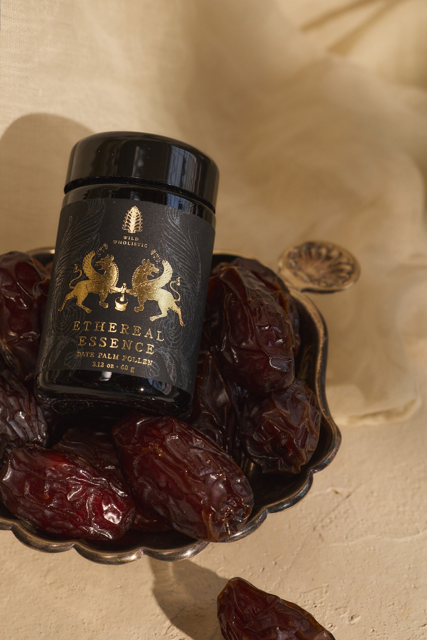 Black jar labeled 'Ethereal Essence' on a decorative tray with dried fruits.