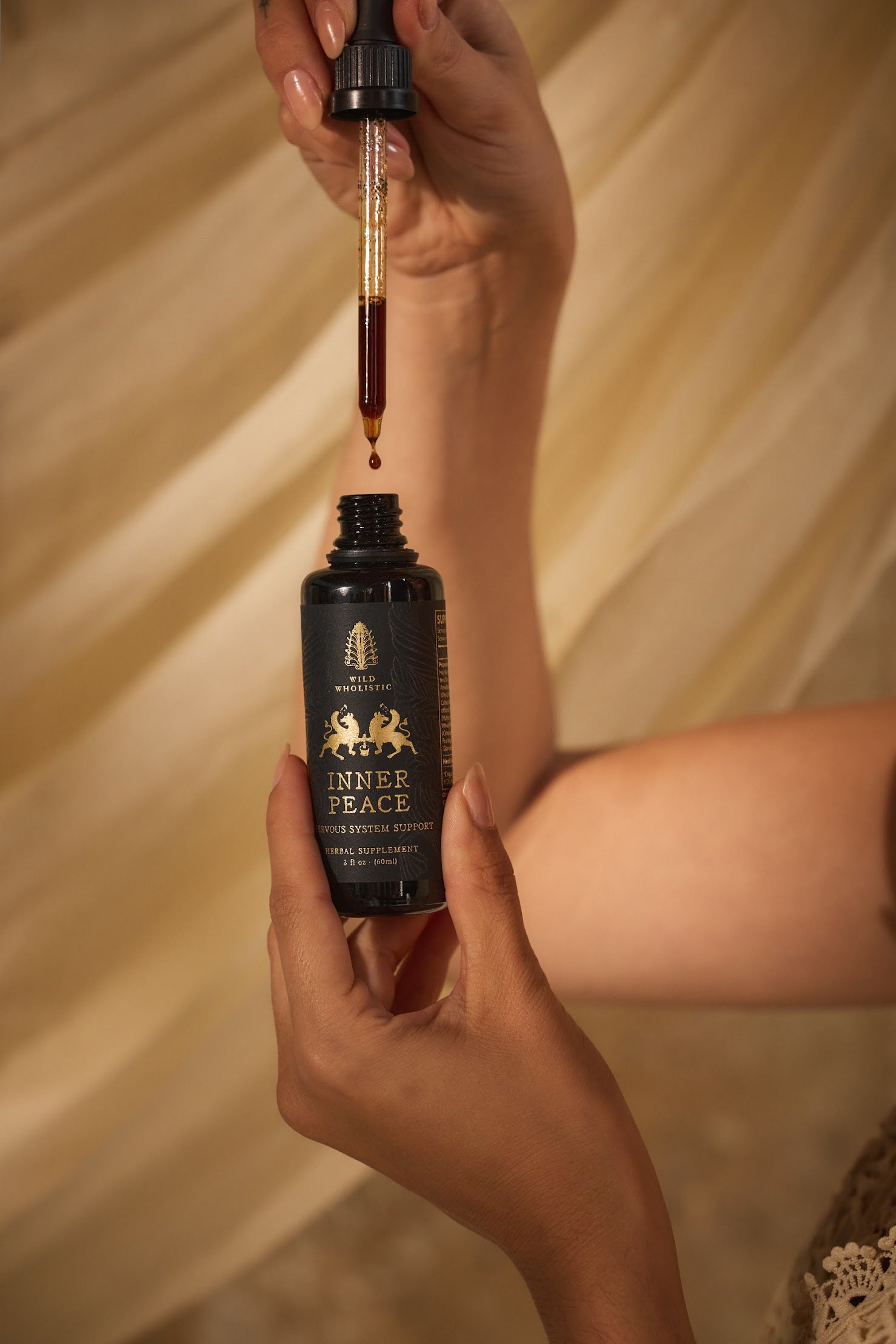 Hand holding a bottle of Inner Peace with a dropper.