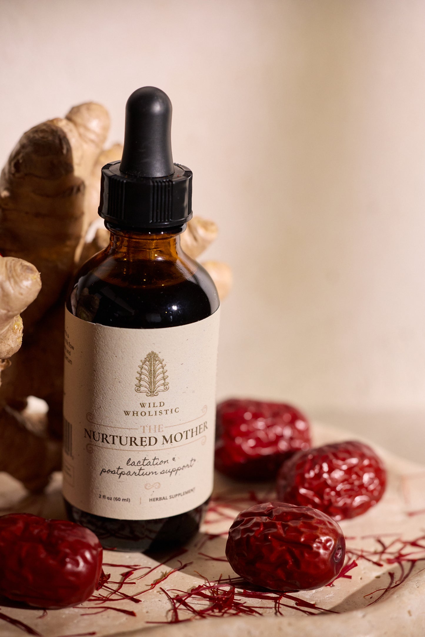 Nurtured Mother tincture bottle and dried red dates with saffron threads and ginger root.